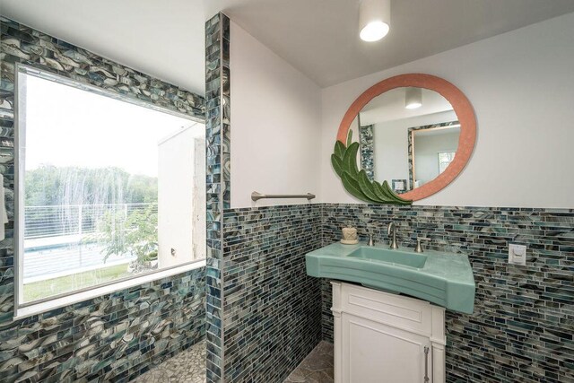 bathroom with vanity and tile walls