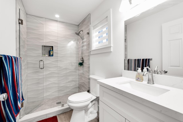 bathroom with vanity, toilet, and a shower with shower door