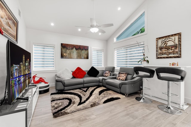 living room with lofted ceiling, ceiling fan, and light hardwood / wood-style flooring