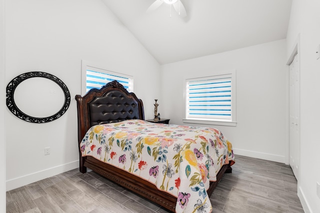 bedroom with multiple windows, lofted ceiling, and light wood-type flooring