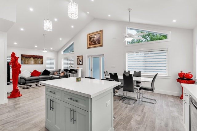 kitchen featuring hanging light fixtures, light hardwood / wood-style flooring, a center island, and ceiling fan