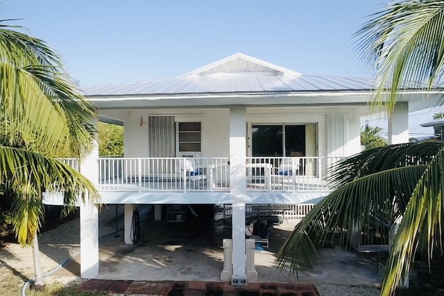 back of house featuring a porch and a carport