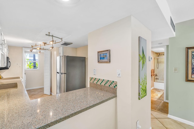 201 E Ocean Dr Unit 110, Key Colony, FL 33051 - kitchen with freestanding refrigerator, light tile patterned floors, and light stone counters