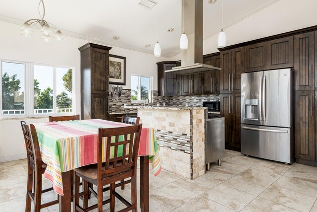 kitchen featuring decorative light fixtures, island range hood, dark brown cabinetry, and stainless steel fridge with ice dispenser