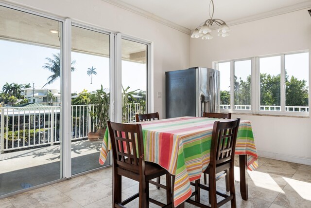 dining room with ornamental molding and a notable chandelier