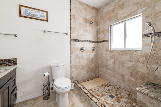 bathroom featuring vanity, toilet, and a tile shower