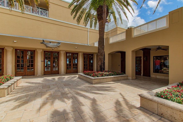 exterior space featuring stucco siding, ceiling fan, and french doors