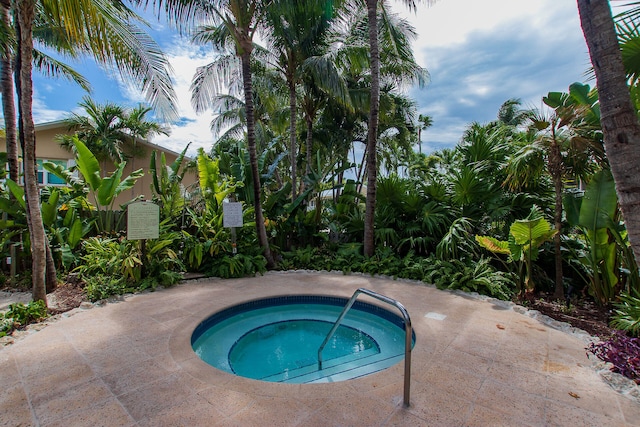 view of swimming pool featuring a hot tub