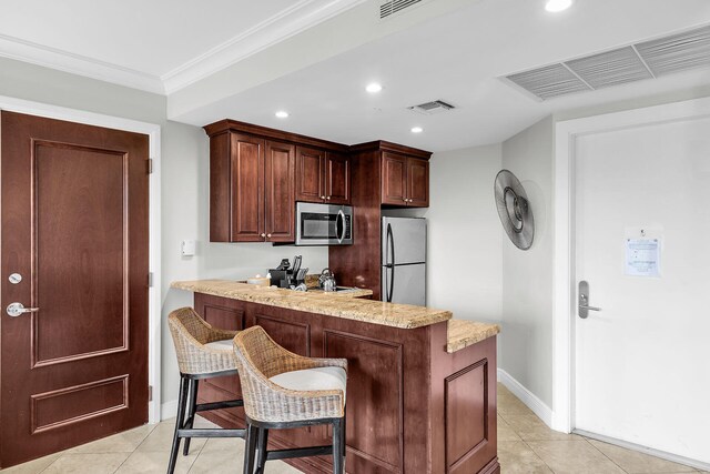 kitchen featuring light tile patterned floors, visible vents, appliances with stainless steel finishes, and ornamental molding