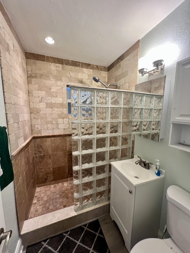 full bathroom featuring a walk in shower, toilet, and vanity