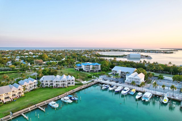 aerial view at dusk featuring a water view