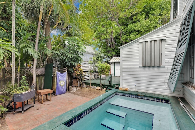 view of pool with fence, a hot tub, and a patio