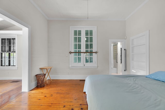 bedroom featuring wood-type flooring, baseboards, and crown molding