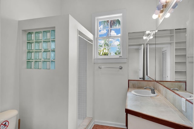bathroom with an inviting chandelier, toilet, vanity, and a shower