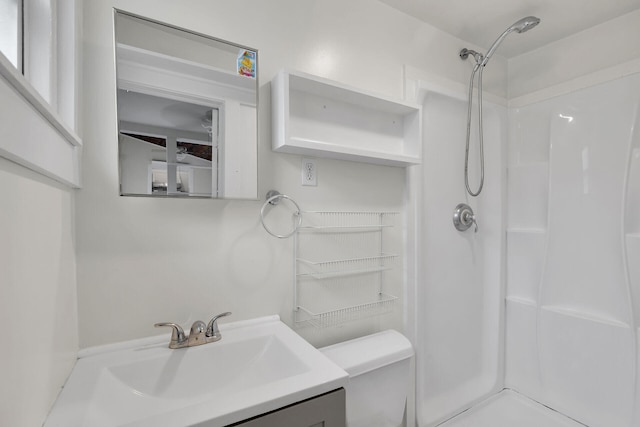 full bathroom featuring a shower stall, toilet, and vanity