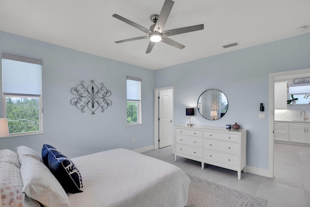bedroom with a sink, baseboards, light tile patterned floors, and visible vents