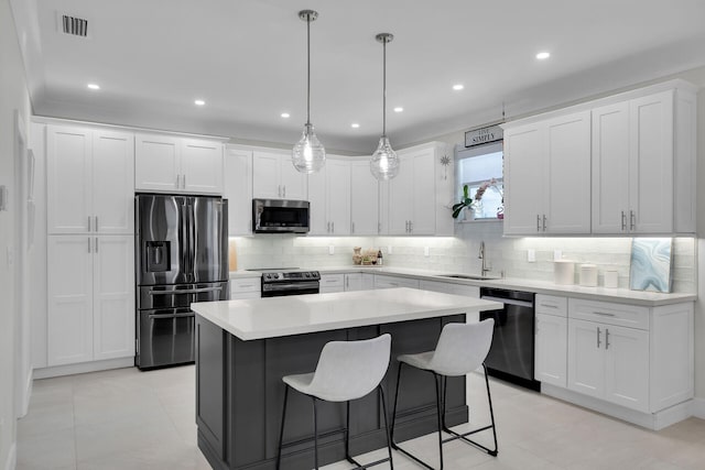 kitchen with tasteful backsplash, appliances with stainless steel finishes, a sink, and a kitchen island