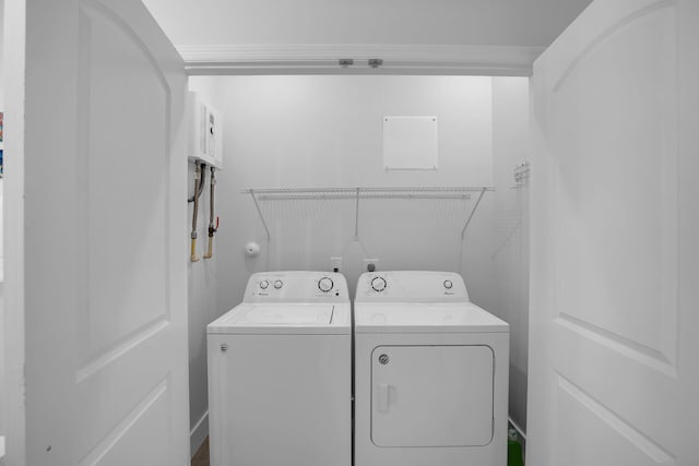 laundry area with laundry area, crown molding, and separate washer and dryer