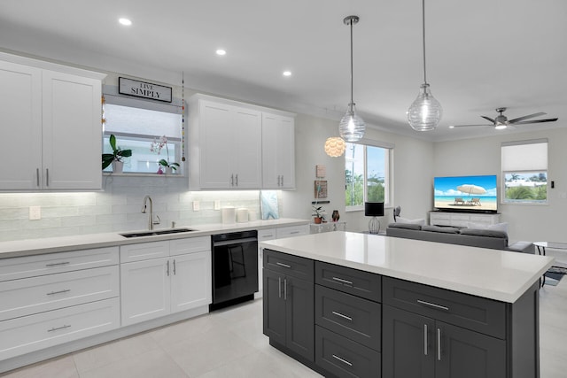 kitchen with a wealth of natural light, black dishwasher, light countertops, and a sink