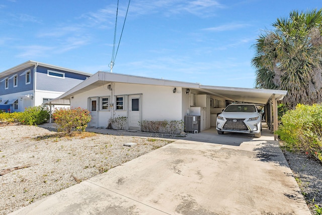 460470 11th St, Key Colony, FL 33051 - view of front facade with driveway, an attached carport, cooling unit, and stucco siding