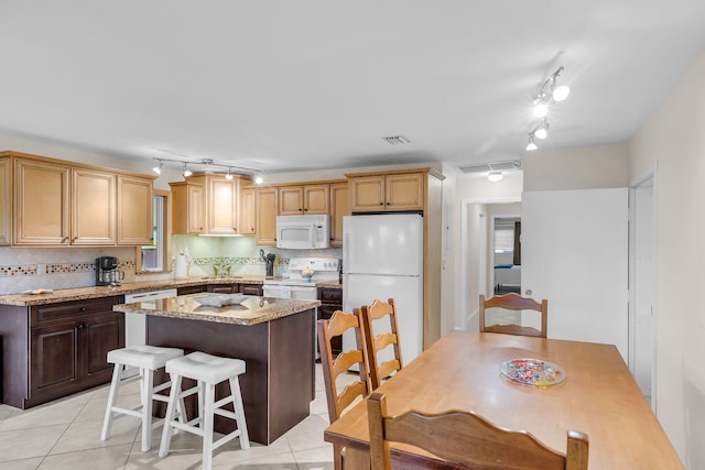 460470 11th St, Key Colony, FL 33051 - kitchen with light tile patterned floors, white appliances, visible vents, decorative backsplash, and a center island