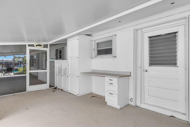 460470 11th St, Key Colony, FL 33051 - kitchen featuring concrete flooring, white cabinetry, and built in study area