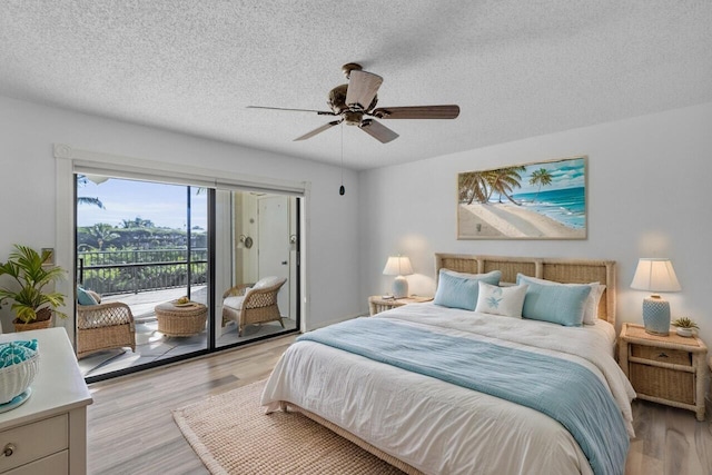 bedroom with access to exterior, a textured ceiling, light wood-style floors, and a ceiling fan