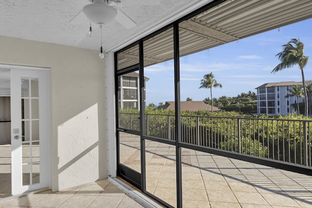 unfurnished sunroom featuring ceiling fan