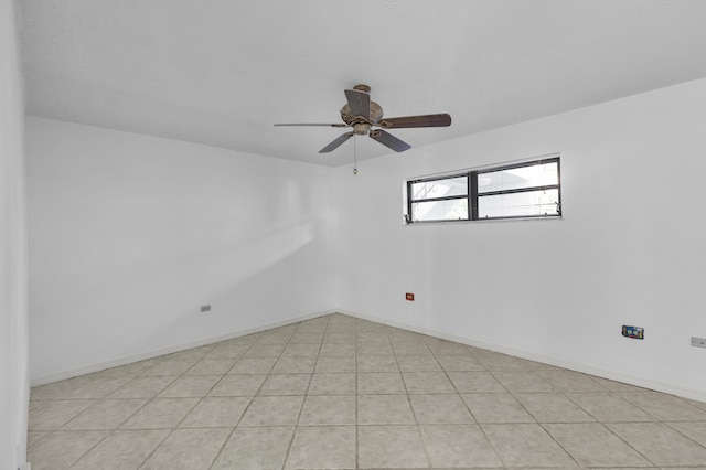 unfurnished room with ceiling fan and baseboards