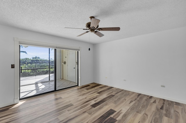 empty room featuring baseboards, light wood-style floors, ceiling fan, and a textured ceiling