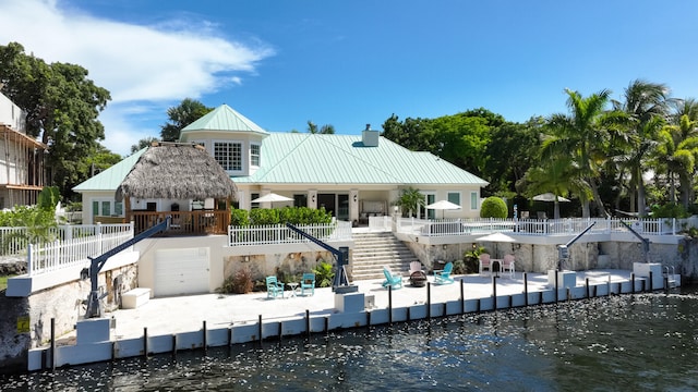 rear view of house with a patio area and a water view