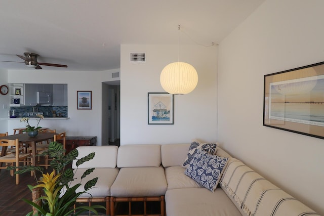 living room featuring visible vents, ceiling fan, and wood finished floors