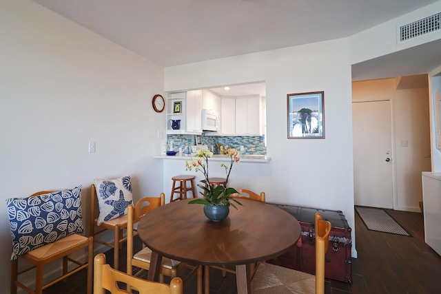 dining area with visible vents and wood finished floors