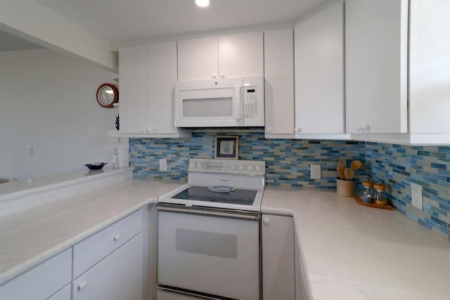 kitchen with white appliances, white cabinets, light countertops, and tasteful backsplash