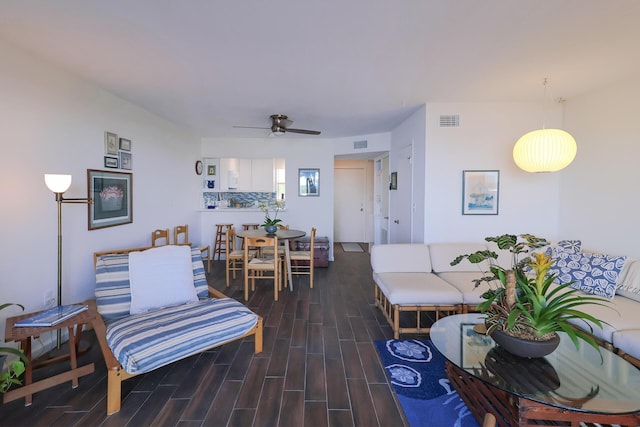 living area with a ceiling fan, wood finished floors, and visible vents