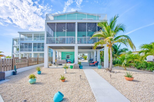 back of property with a sunroom, a patio, and ceiling fan