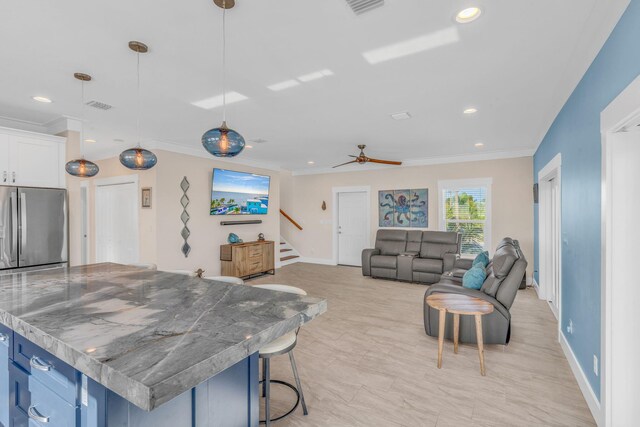 living room featuring ornamental molding and ceiling fan