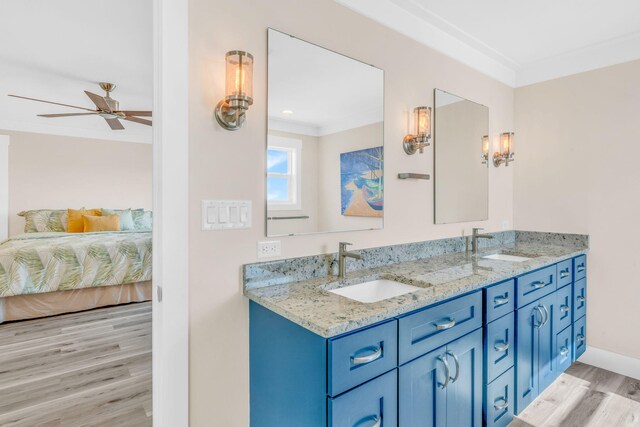 bathroom featuring hardwood / wood-style flooring, vanity, ceiling fan, and crown molding