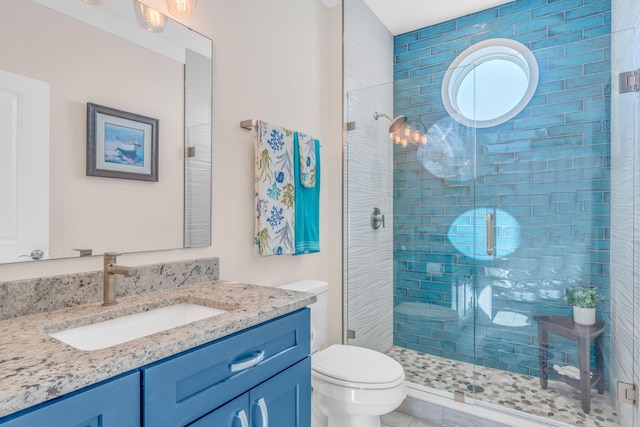 bathroom featuring vanity, toilet, and an enclosed shower