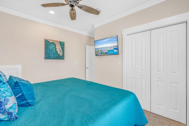 bedroom featuring ornamental molding, hardwood / wood-style floors, ceiling fan, and a closet