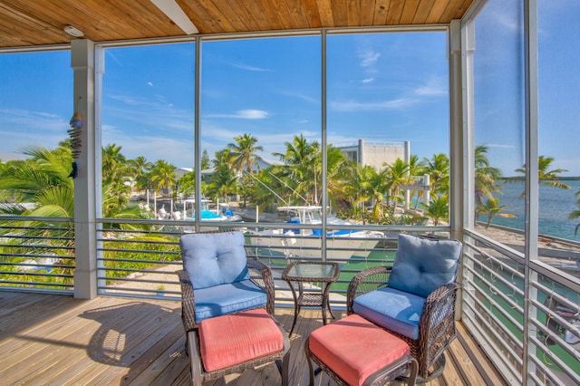 sunroom / solarium with wood ceiling and a water view