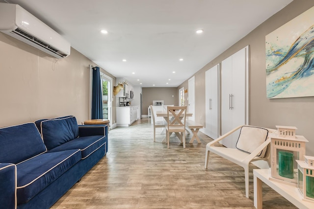 living room featuring a wall mounted AC and light hardwood / wood-style flooring