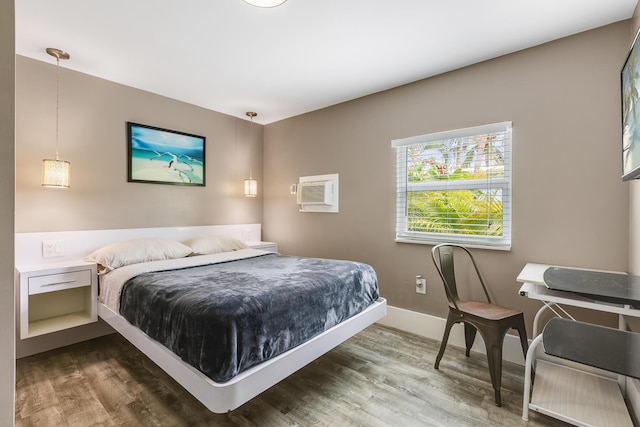 bedroom with wood-type flooring and a wall mounted AC