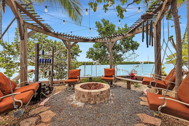 view of patio with a water view, a pergola, and a fire pit