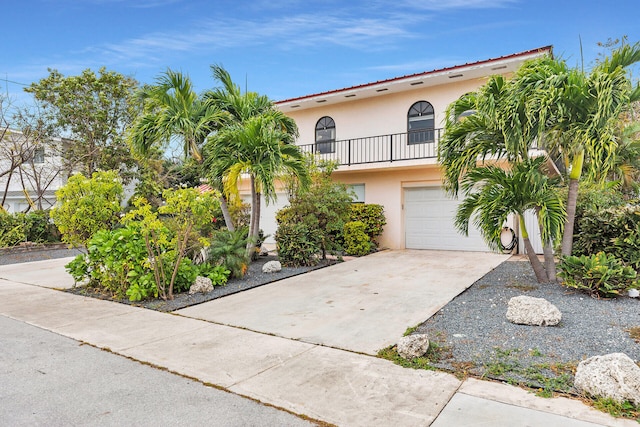 view of front of property featuring a balcony and a garage