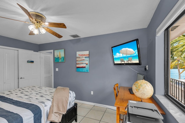 tiled bedroom with access to exterior, ceiling fan, and a closet