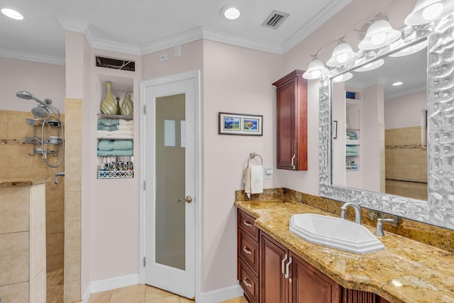 bathroom featuring ornamental molding, tiled shower, vanity, and tile patterned floors