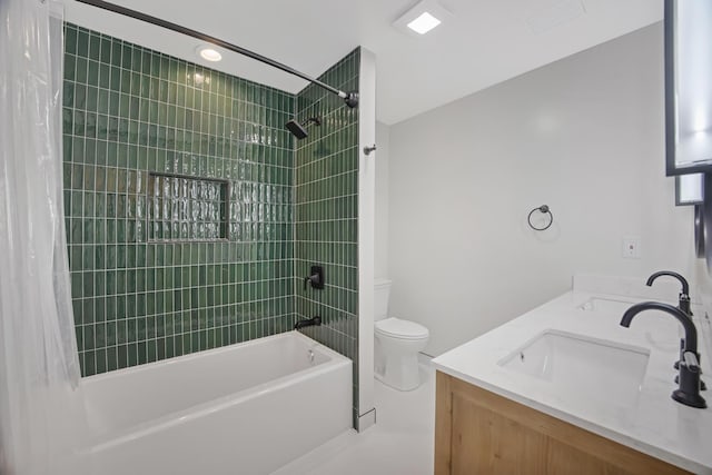 bathroom featuring double vanity, toilet, shower / tub combo, and a sink