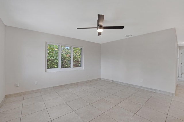spare room featuring light tile patterned floors, visible vents, and ceiling fan