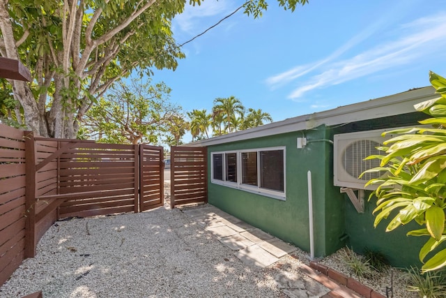 view of side of home featuring fence, a patio, and stucco siding